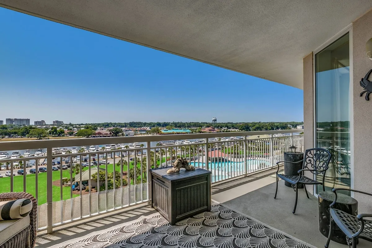 The image showcases the expansive balcony of the North Myrtle Beach condo, furnished with inviting outdoor seating and decorative touches. The scene offers a sweeping view ideal for sunset watching, relaxing, or entertaining, evoking a tranquil resort atmosphere just steps from the coast.